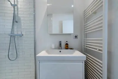 a white bathroom with a sink and a shower at Résidence 4p Carré D’or - Hyper Centre à Pied Des Plages - 4P Carré d’or - Hyper centre à pied des plages MAE-1973 in Cannes