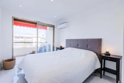 a bedroom with a white bed and a large window at Résidence 2 Pièces Cozy à 5 Minutes à Pied De La Croisette - 2 pièces cozy à 5 minutes à pied de la Croisette MAE-1983 in Cannes