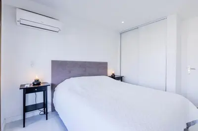 a white bedroom with a large bed and two night stands at Résidence 2 Pièces Cozy à 5 Minutes à Pied De La Croisette - 2 pièces cozy à 5 minutes à pied de la Croisette MAE-1983 in Cannes