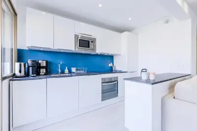 a kitchen with white cabinets and a microwave at Résidence 2 Pièces Cozy à 5 Minutes à Pied De La Croisette - 2 pièces cozy à 5 minutes à pied de la Croisette MAE-1983 in Cannes