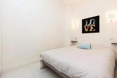 a white bedroom with a bed and a picture on the wall at Résidence 3p Moderne Et Cosy Aux Pieds De La Croisette ! - 3P moderne et cosy aux pieds de la Croisette ! MAE-2003 in Cannes