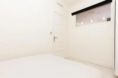 a white bedroom with a bed and a window at Résidence 3p Moderne Et Cosy Aux Pieds De La Croisette ! - 3P moderne et cosy aux pieds de la Croisette ! MAE-2003 in Cannes
