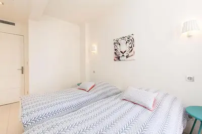 a white bedroom with a bed and a picture on the wall at Résidence 3p Moderne Et Cosy Aux Pieds De La Croisette ! - 3P moderne et cosy aux pieds de la Croisette ! MAE-2003 in Cannes