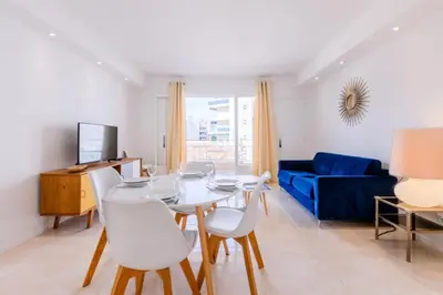 a living room with a table and chairs and a blue couch at Résidence 3p De Style Avec Balcon à 3 Min De La Croisette - 3P de style avec balcon à 3 min de la Croisette MAE-2013 in Cannes