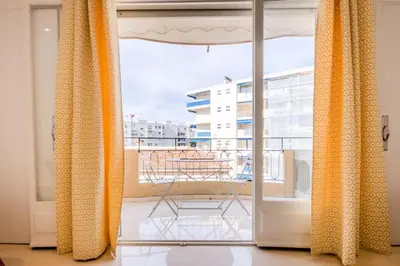 a balcony with curtains and a view of a building at Résidence 3p De Style Avec Balcon à 3 Min De La Croisette - 3P de style avec balcon à 3 min de la Croisette MAE-2013 in Cannes