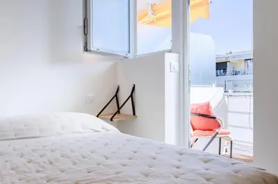 a bedroom with a bed and a window with a chair at Résidence 2p De Style Avec Terrasse, Domaine Privé Palm Beach - 2P de style avec terrasse, domaine privé Palm Beach MAE-2053 in Cannes