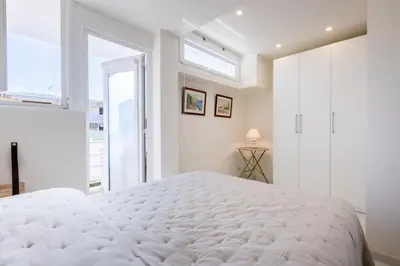 a white bedroom with a large bed and a window at Résidence 2p De Style Avec Terrasse, Domaine Privé Palm Beach - 2P de style avec terrasse, domaine privé Palm Beach MAE-2053 in Cannes