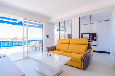 a living room with a yellow couch and a table at Résidence 2p Avec Terrasse Vue Mer & Parking, 2min Des Plages - 2P avec terrasse vue mer & parking, 2min des plages MAE-2063 in Cannes