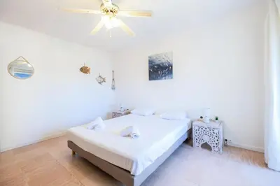 a white bedroom with a bed and a ceiling fan at Résidence 3p à 100m Des Plages, Terrasse Et Parking - 3P à 100m des plages, terrasse et parking MAE-2073 in Cannes