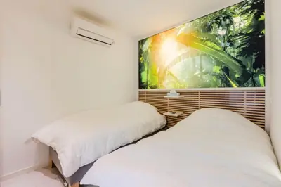 two beds in a room with a large painting on the wall at Résidence 4p De 96m² Sur Les Hauteurs De Cannes - 4P de 96m² sur les hauteurs de Cannes MAE-2083 in Cannes