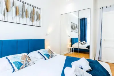 a bedroom with a large bed and a mirror at Résidence 4p Au Cœur Du Centre Ville - 5 Min Palais & Plages - 4P au cœur du centre ville - 5 min Palais & Plages MAE-2093 in Cannes