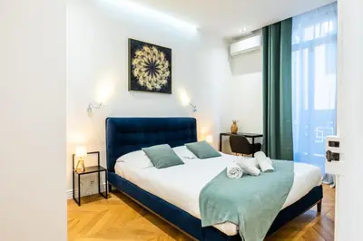 a bedroom with a large bed with a blue headboard at Résidence 4p Au Cœur Du Centre Ville - 5 Min Palais & Plages - 4P au cœur du centre ville - 5 min Palais & Plages MAE-2093 in Cannes