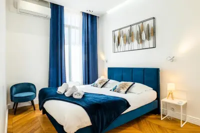 a bedroom with a blue bed and a blue chair at Résidence 4p Au Cœur Du Centre Ville - 5 Min Palais & Plages - 4P au cœur du centre ville - 5 min Palais & Plages MAE-2093 in Cannes