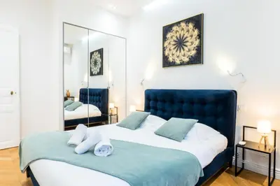 a bedroom with a large bed and a mirror at Résidence 4p Au Cœur Du Centre Ville - 5 Min Palais & Plages - 4P au cœur du centre ville - 5 min Palais & Plages MAE-2093 in Cannes