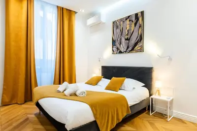 a bedroom with a large bed with yellow curtains at Résidence 4p Au Cœur Du Centre Ville - 5 Min Palais & Plages - 4P au cœur du centre ville - 5 min Palais & Plages MAE-2093 in Cannes