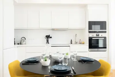 a kitchen with a black table and yellow chairs at Résidence 4p Au Cœur Du Centre Ville - 5 Min Palais & Plages - 4P au cœur du centre ville - 5 min Palais & Plages MAE-2093 in Cannes