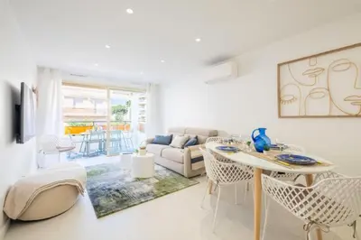 a white living room with a table and chairs at Résidence 3p De Style à Deux Pas De La Croisette & Commerces - 3P de style à deux pas de la Croisette & commerces MAE-2103 in Cannes