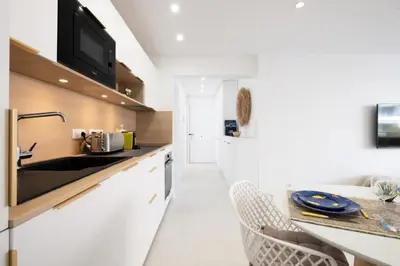 a white kitchen with a sink and a counter at Résidence 3p De Style à Deux Pas De La Croisette & Commerces - 3P de style à deux pas de la Croisette & commerces MAE-2103 in Cannes