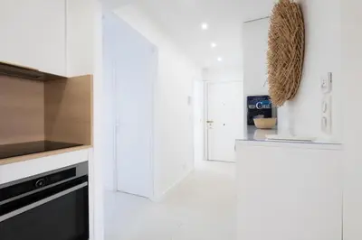 a kitchen with white walls and a black and white oven at Résidence 3p De Style à Deux Pas De La Croisette & Commerces - 3P de style à deux pas de la Croisette & commerces MAE-2103 in Cannes