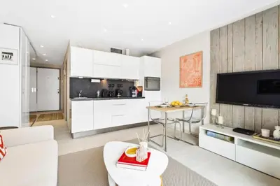 a living room with white furniture and a kitchen at Résidence Centre Ville De Cannes, 2p Moderne Avec Terrasse - Centre ville de Cannes, 2P moderne avec terrasse MAE-2133 in Cannes