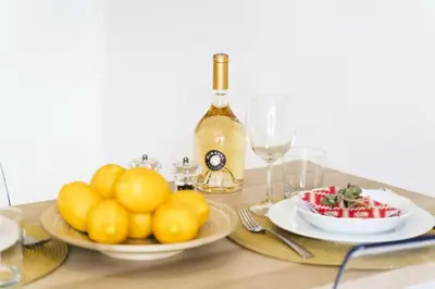 a table with a plate of fruit and a bottle of wine at Résidence Centre Ville De Cannes, 2p Moderne Avec Terrasse - Centre ville de Cannes, 2P moderne avec terrasse MAE-2133 in Cannes
