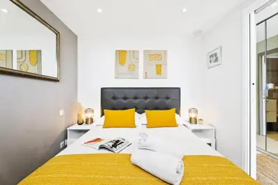 a bedroom with a large bed with yellow pillows at Résidence Centre Ville De Cannes, 2p Moderne Avec Terrasse - Centre ville de Cannes, 2P moderne avec terrasse MAE-2133 in Cannes
