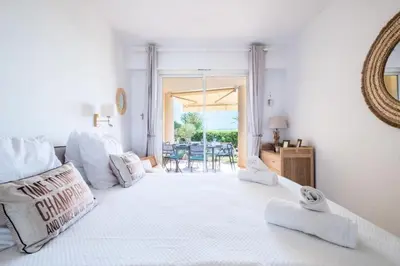 a white bedroom with a large white bed with a mirror at Résidence Rare ! Superbe 3 Pièces Avec Jardin Face à La Mer - RARE ! Superbe 3 pièces avec jardin face à la mer MAE-2143 in Cannes