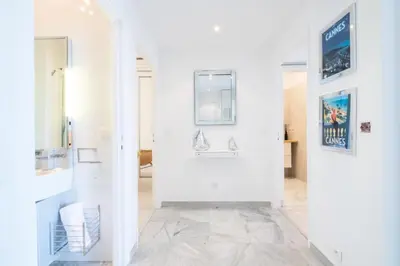 a hallway with white walls and a tile floor at Résidence Rare ! Superbe 3 Pièces Avec Jardin Face à La Mer - RARE ! Superbe 3 pièces avec jardin face à la mer MAE-2143 in Cannes