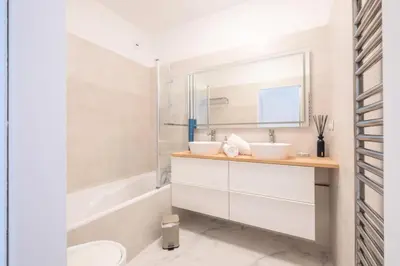 a bathroom with two sinks and a tub and a mirror at Résidence Rare ! Superbe 3 Pièces Avec Jardin Face à La Mer - RARE ! Superbe 3 pièces avec jardin face à la mer MAE-2143 in Cannes