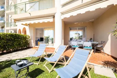 a group of chairs and tables on a patio with a table at Résidence Rare ! Superbe 3 Pièces Avec Jardin Face à La Mer - RARE ! Superbe 3 pièces avec jardin face à la mer MAE-2143 in Cannes