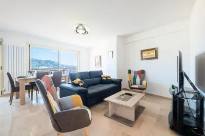 a living room with a blue couch and a tv at Résidence 4p Proche Hyper Centre, Vue Mer, Parking - 4P proche hyper centre, vue mer, parking MAE-2153 in Cannes