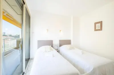 two beds in a room with a window at Résidence 4p Proche Hyper Centre, Vue Mer, Parking - 4P proche hyper centre, vue mer, parking MAE-2153 in Cannes