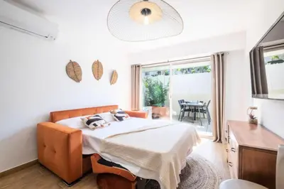 a bedroom with a bed in a room with a table at Résidence Appartement Avec Piscine Résidentiel - Appartement avec piscine résidentiel MAE-2183 in Cannes