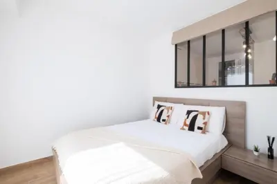 a bedroom with white walls and a bed with pillows at Résidence Appartement Avec Piscine Résidentiel - Appartement avec piscine résidentiel MAE-2183 in Cannes
