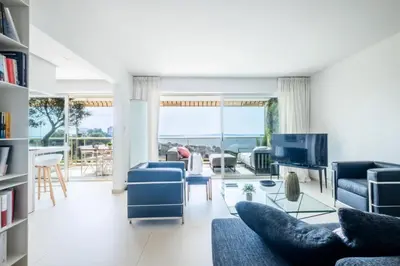 a living room with blue chairs and a tv at Résidence 3p, Terrasse Aménagée, Piscine, Vue Sur Les îles - 3P, terrasse aménagée, piscine, vue sur les îles MAE-2193 in Cannes