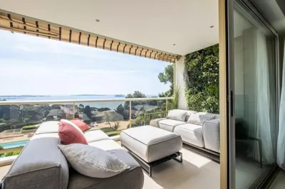 a balcony with a couch and a view of the ocean at Résidence 3p, Terrasse Aménagée, Piscine, Vue Sur Les îles - 3P, terrasse aménagée, piscine, vue sur les îles MAE-2193 in Cannes