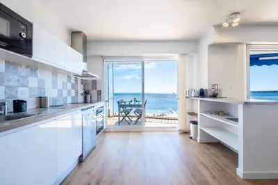 a kitchen with white cabinets and a view of the ocean at Résidence Rare ! 3p En Front De Mer - RARE ! 3P en front de mer MAE-2213 in Cannes