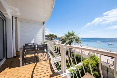 a balcony with a table and chairs and the beach at Résidence Rare ! 3p En Front De Mer - RARE ! 3P en front de mer MAE-2213 in Cannes