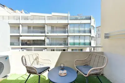 two chairs and a table on a balcony with a building at Résidence 2p Hyper Centre Cannes, 100 Plages - 2P hyper centre Cannes, 100 plages MAE-2223 in Cannes