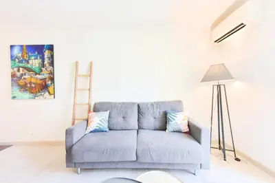 a blue couch in a living room with a painting at Résidence 2p Hyper Centre Cannes, 100 Plages - 2P hyper centre Cannes, 100 plages MAE-2223 in Cannes
