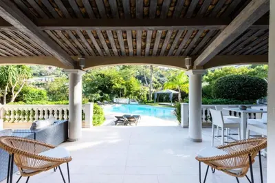 a patio with chairs and a table and a pool at Résidence Villa 330m2, 6 Chambres, Piscine Chauffée Jacuzzi - Villa 330m2, 6 chambres, piscine chauffée jacuzzi MAE-2233 in Vallauris