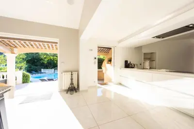 an open kitchen with white countertops and a pool at Résidence Villa 330m2, 6 Chambres, Piscine Chauffée Jacuzzi - Villa 330m2, 6 chambres, piscine chauffée jacuzzi MAE-2233 in Vallauris