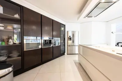 a kitchen with black cabinets and a stainless steel refrigerator at Résidence Villa 330m2, 6 Chambres, Piscine Chauffée Jacuzzi - Villa 330m2, 6 chambres, piscine chauffée jacuzzi MAE-2233 in Vallauris