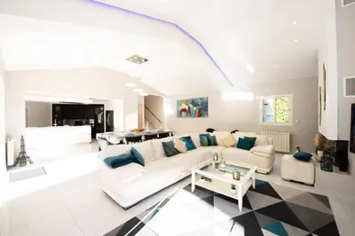 a living room with a white couch and a table at Résidence Villa 330m2, 6 Chambres, Piscine Chauffée Jacuzzi - Villa 330m2, 6 chambres, piscine chauffée jacuzzi MAE-2233 in Vallauris