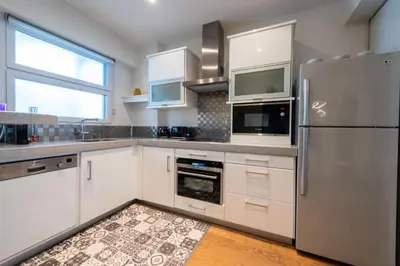 a kitchen with white cabinets and a stainless steel refrigerator at Résidence 3p Avec Terrasse Vue Mer, Face Au Martinez - 3P avec terrasse vue mer, face au Martinez MAE-2243 in Cannes