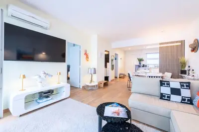 a living room with a couch and a tv at Résidence 3p Avec Terrasse Vue Mer, Face Au Martinez - 3P avec terrasse vue mer, face au Martinez MAE-2243 in Cannes