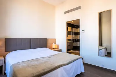 a bedroom with a large bed and a mirror at Résidence 3 Pièces Rue D’antibes à Deux Pas Du Palais Des Festivals - 3 pièces rue d’Antibes à deux pas du Palais des festivals MAE-2263 in Cannes