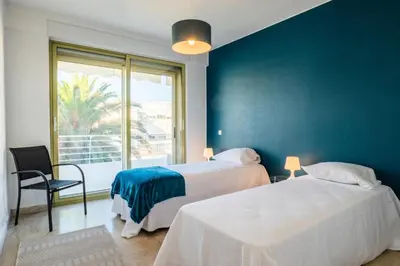 two beds in a room with a blue wall at Résidence Vue Mer Panoramique - 3 Pièces Mouré Rouge - VUE MER PANORAMIQUE - 3 pièces Mouré Rouge MAE-2293 in Cannes