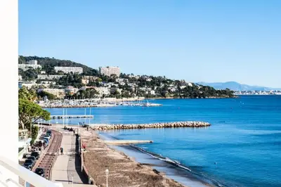 a view of a beach with blue water and buildings at Résidence Vue Mer Panoramique - 3 Pièces Mouré Rouge - VUE MER PANORAMIQUE - 3 pièces Mouré Rouge MAE-2293 in Cannes