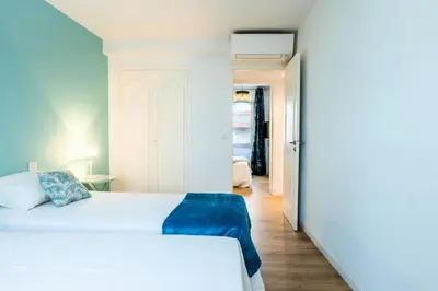 a bedroom with a white bed and a hallway at Résidence 4p De Style à Deux Pas Du Palais Des Festivals - 4P de style à deux pas du Palais des festivals MAE-2303 in Cannes
